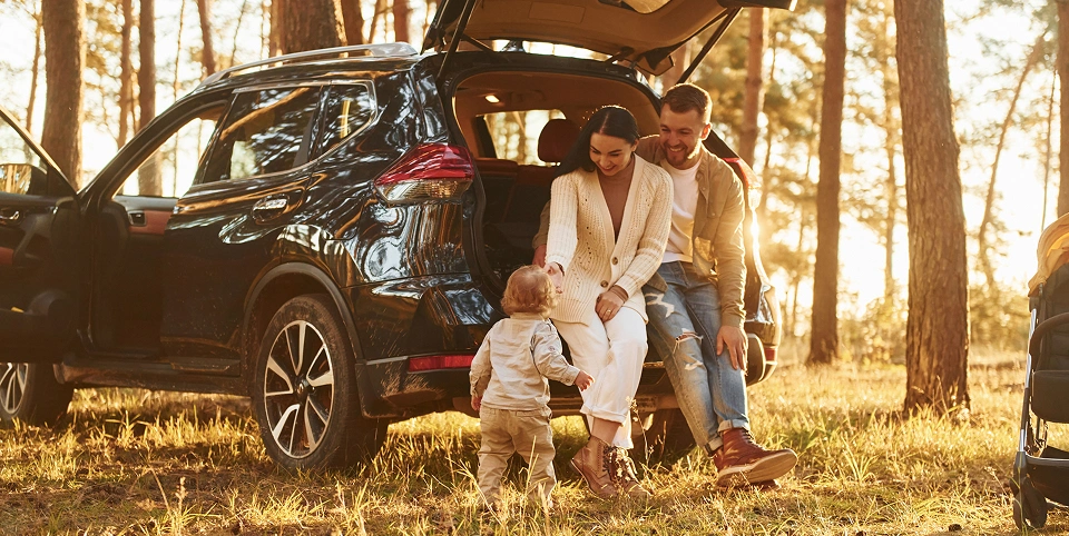 Familie în vacanță lângă o mașină